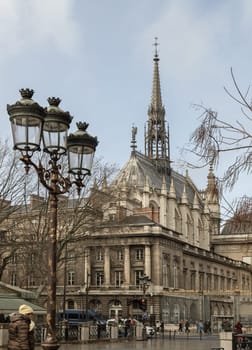 France, Paris - Jan 03, 2024 - The front entrance to Palais du Justice and famous Sainte-Chapelle with street lantern in front of, The Holy Chapel is Gothic spire architecture on Ile de la Cite in Paris, Space for text, Selective focus.