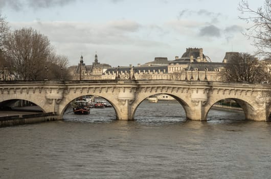 France, Paris - Jan 03, 2024 - The Pont Neuf is the oldest bridge across the seine river with view in paris city. Old stone bridge with many human face sculptures on it, Space for text, Selective focus.