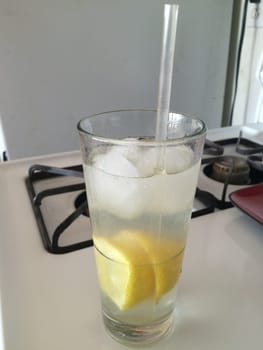 Tall Glass of Icy Cold Lemon Water in the Kitchen on a Hot Day. High quality photo