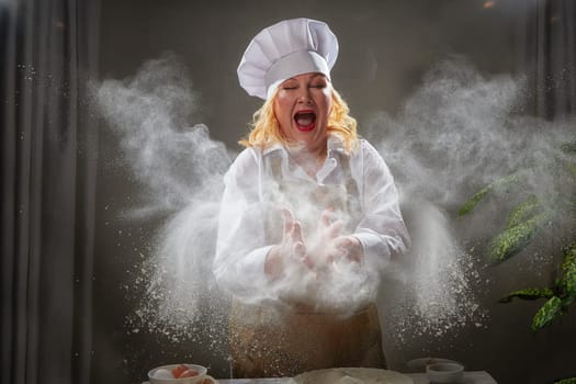 Fat funny female cook in a hat and apron posing and taking selfie in the kitchen with flour. Cooking, body positive, cloud, smoke, flour