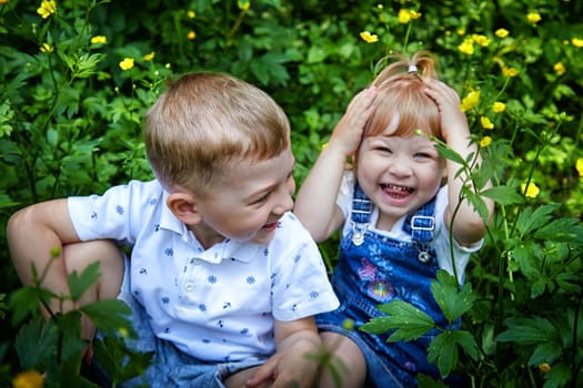 Cute kids in flowers in nature. Funny Boy and girl in grass. A good environment means Healthy, happy children