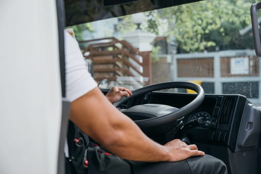 Businessman mover steering truck for home relocation service. Successful teamwork in delivering and unloading. Smiling man in uniform working. Moving Day Concept.