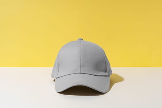 Baseball hat against yellow background in studio close up