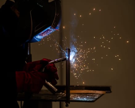A man learns the craft of welding on a sample