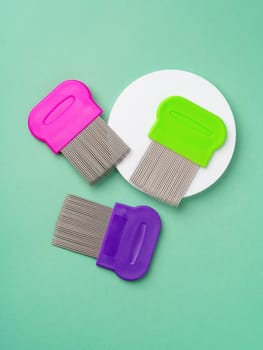 Three combs for lice removing on green background close up