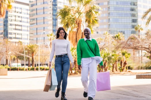 two young female friends smiling happy walking in a shopping area, friendship and modern lifestyle concept