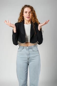 Young Curly Clueless Woman Holding Out Hands in studio