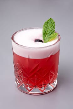 red cocktail with mint Clover Club on a gray background.