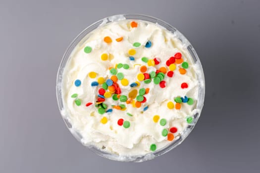 milkshake with bright confetti top view on gray background.