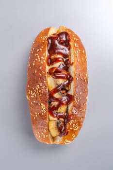 hot dog with ketchup and mushrooms. On a gray table