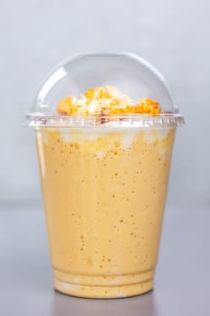 sweet milk cocktail with popcorn in a plastic glass.