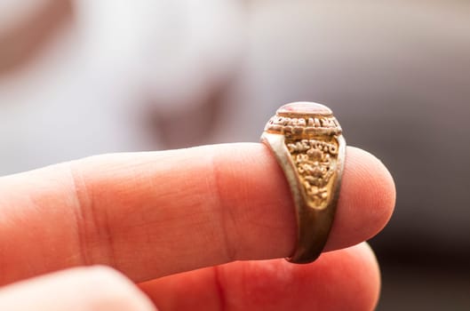 Close up shot of an old, vintage ring with some latin words in it