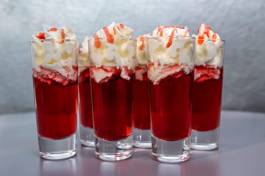set of red cocktails with cream on a gray background.
