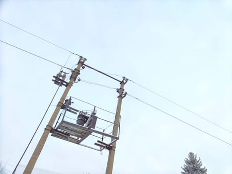 Old power line pole and transformer against blue sky in a nice sunny day