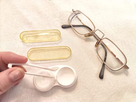 Set for contact lenses with a container, forceps, glasses. The concept of correcting myopia. Contact lens care, cleaning, health. Background, copy space