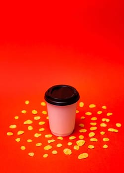 white paper cup with corn flakes on a red background.