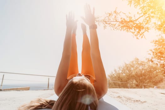 Fitness woman sea. Outdoor workout on yoga mat in park near to ocean beach. Female fitness pilates yoga routine concept. Healthy lifestyle. Happy fit woman exercising with rubber band in park.