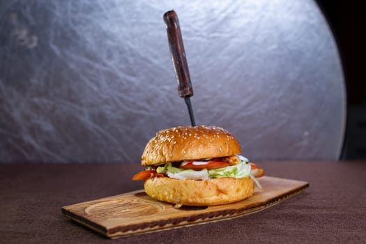 knife in fresh burger with juicy patty.