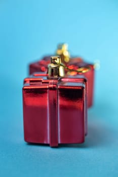 Christmas tree toy in the form of a red gift on a blue background.