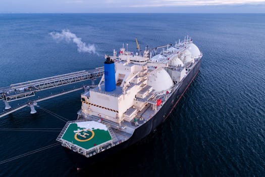 Aerial of Liquified Natural Gas LNG carrier moored to a small gas terminal. Fuel crisis. Sanctions.