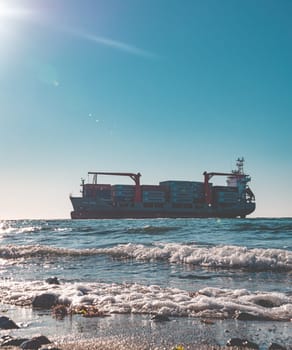 Container cargo ship stands aground after a storm.