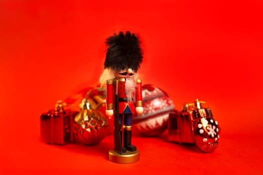 christmas nutcracker figurine with decorations on a red background.