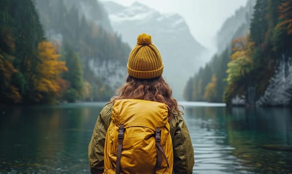 A person with a backpack standing near a body of water.