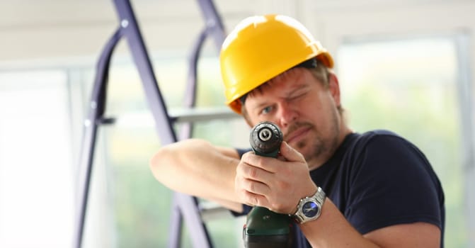 Arms of worker using electric drill closeup. Manual job DIY inspiration improvement job fix shop yellow helmet joinery startup idea industrial education profession career concept