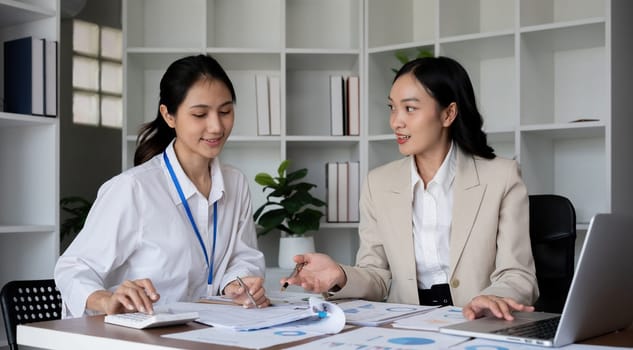 Team businesswomen discussing financial reports in office.