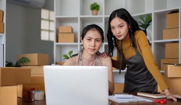 Stressed young women in warehouse, dealing with packaging issues and inventory problems.