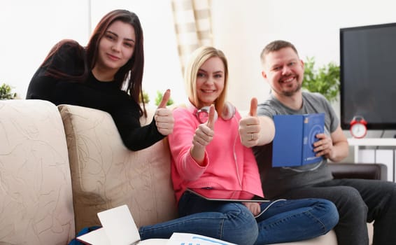 group of friends spend time together sit on sofa in livingroom show big finger enjoy weekends