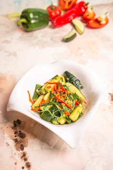 Garnish of fresh cucumbers, bell peppers, and herbs on a white plate on a solid pink background. Isolated. Healthy eating concept.