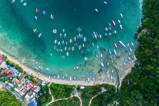 Top drone view of a traditional philippine boats on the surface of the azure water in the lagoon. Summer and travel vacation concept