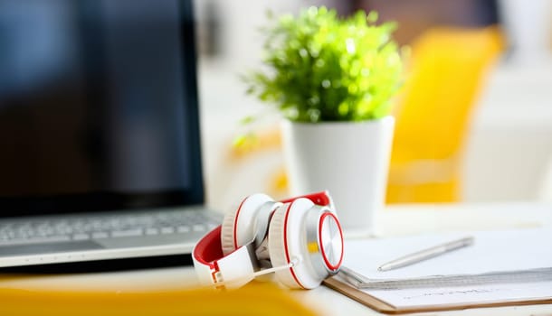 Empty remote office workplace with laptop pc and headset closeup. Receptionist or secretary of contact data center desktop keyboard device desk table ip telephony or callcenter voice message system