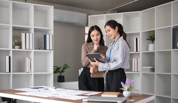 A team of business people who support each other's work Work consultants and employees discuss working on business documents together..