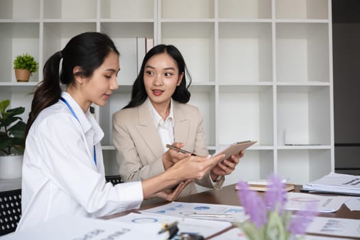 A team of business people who support each other's work Work consultants and employees discuss working on business documents together..