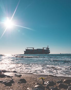 Container cargo ship stands aground after a storm.