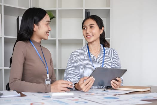 A team of business people who support each other's work Work consultants and employees discuss working on business documents together..