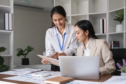 A team of business people who support each other's work Work consultants and employees discuss working on business documents together..