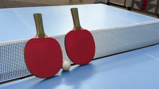 Rackets and ball on a blue tennis table - equipment for table tennis or ping pong. Old and new rackets close-up. Sports concept. . High quality photo