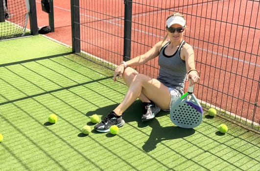 Happy female paddle tennis player during practice on outdoor court. Copy space. High quality photo