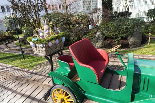 Attraction for children, car in an amusement park decorated with Easter eggs and bunnies. Entertainment for Easter.