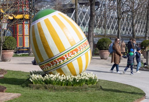 Large decorotive Easter egg on the grass in the park. Easter concept. Copenhagen, Denmark - March 28, 2024