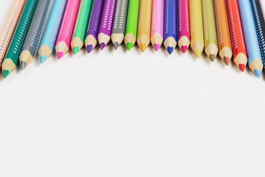 Colored pencils for drawing various colors on a white background. High quality photo