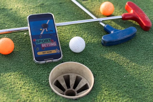 golf equipment on the green lawn. mini golf sports betting on a smartphone. High quality photo