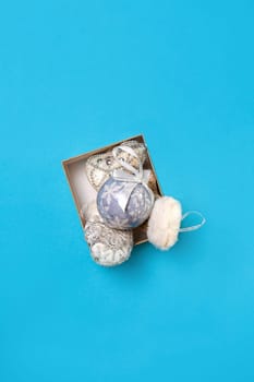 Christmas toys in a box are isolated on a blue background