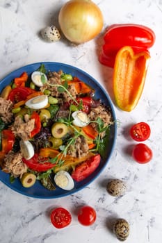 nicoise salad on the table with vegetables top view.