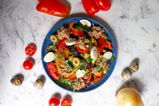 nicoise salad with tuna on the table with vegetables top view.