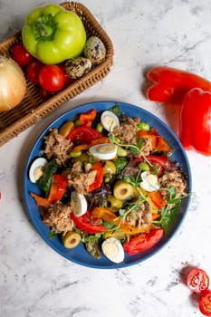 nicoise salad with tuna on the table with vegetables top view.