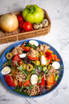 nicoise salad with tuna on the table with vegetables top view.